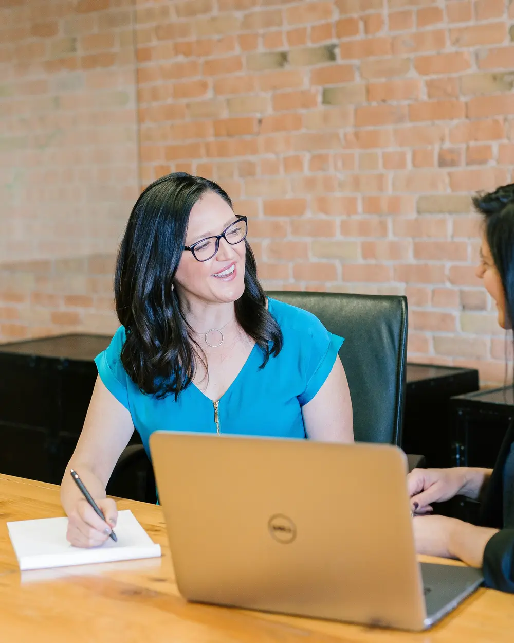 A practice manager and a colleague looking at a laptop together