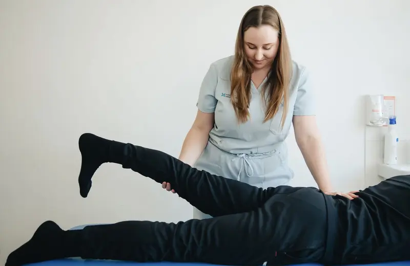 A physical therapist guiding a patient through a leg stretch