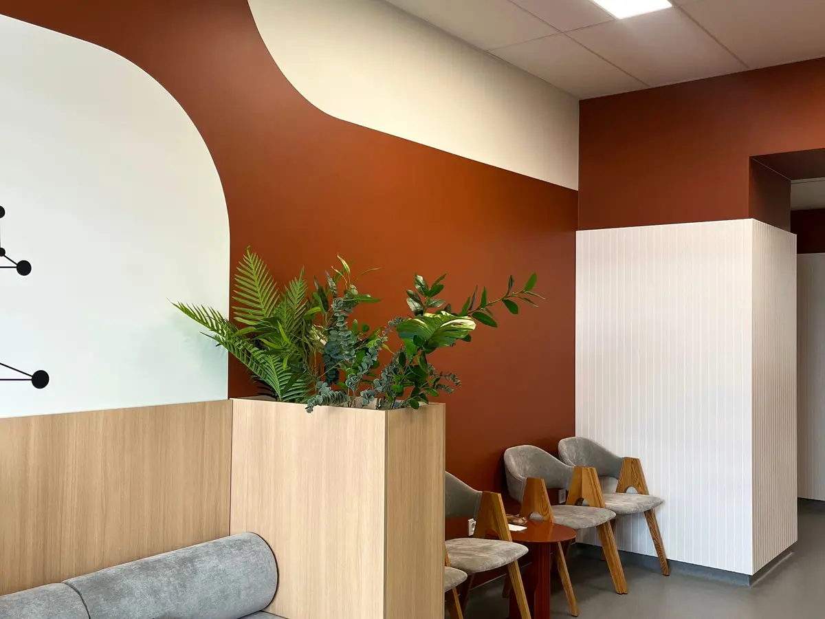 A warm, modern waiting room with plants.