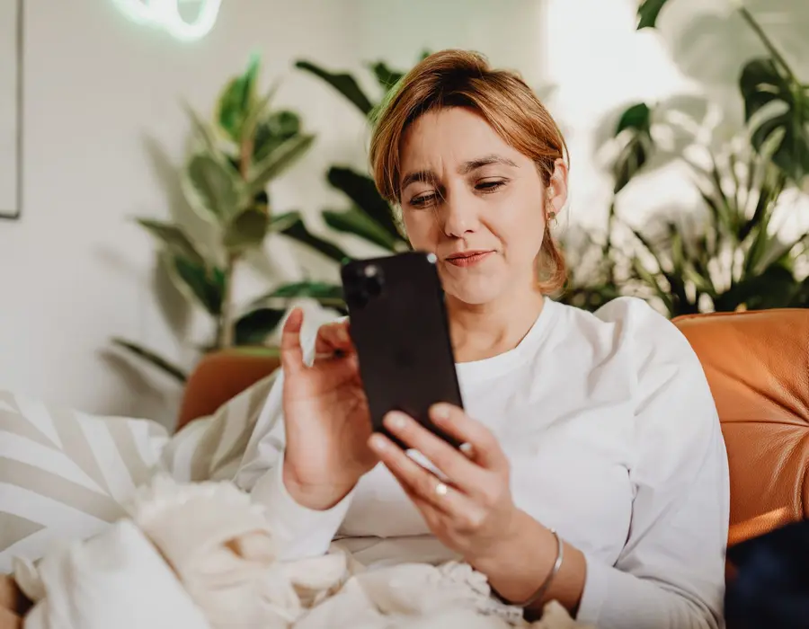 A woman looking at her phone at home